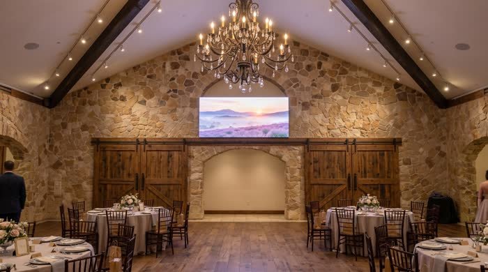 LED display above doors in a stone-walled wedding venue